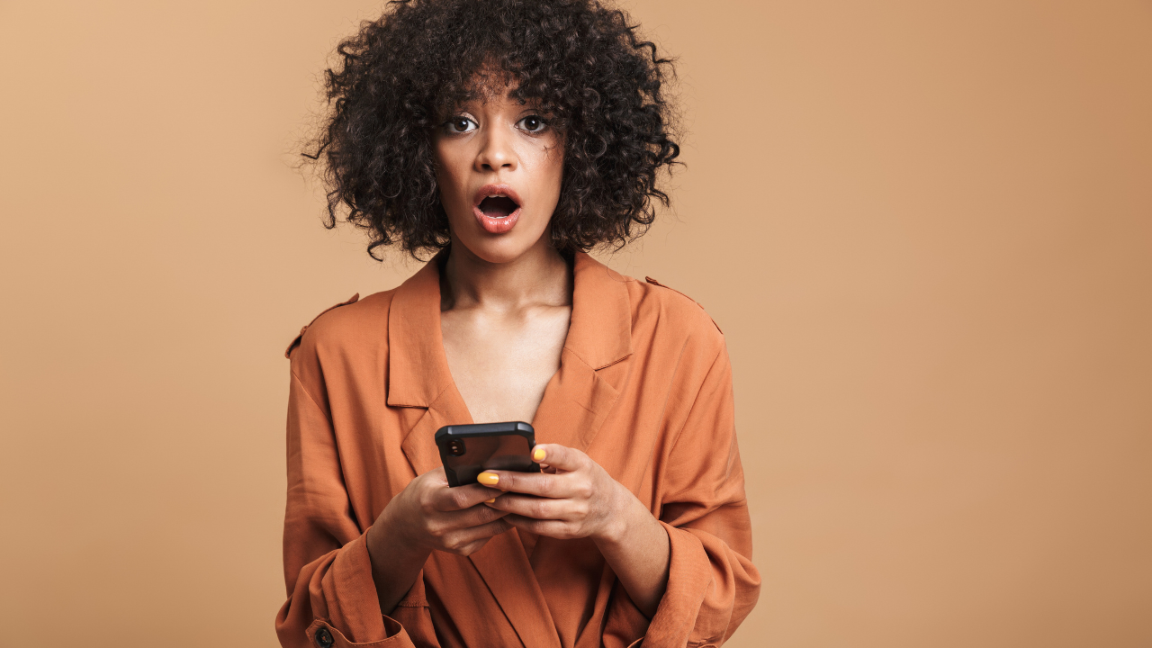 woman shocked holding phone
